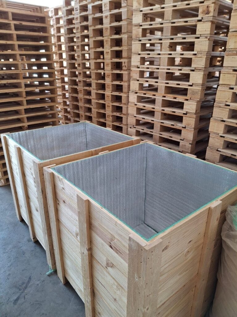 Wooden boxes with inside shock absorption panels in a warehouse.
