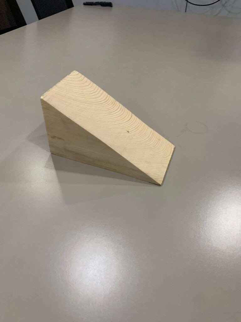 A wooden wedge sitting on top of a table.