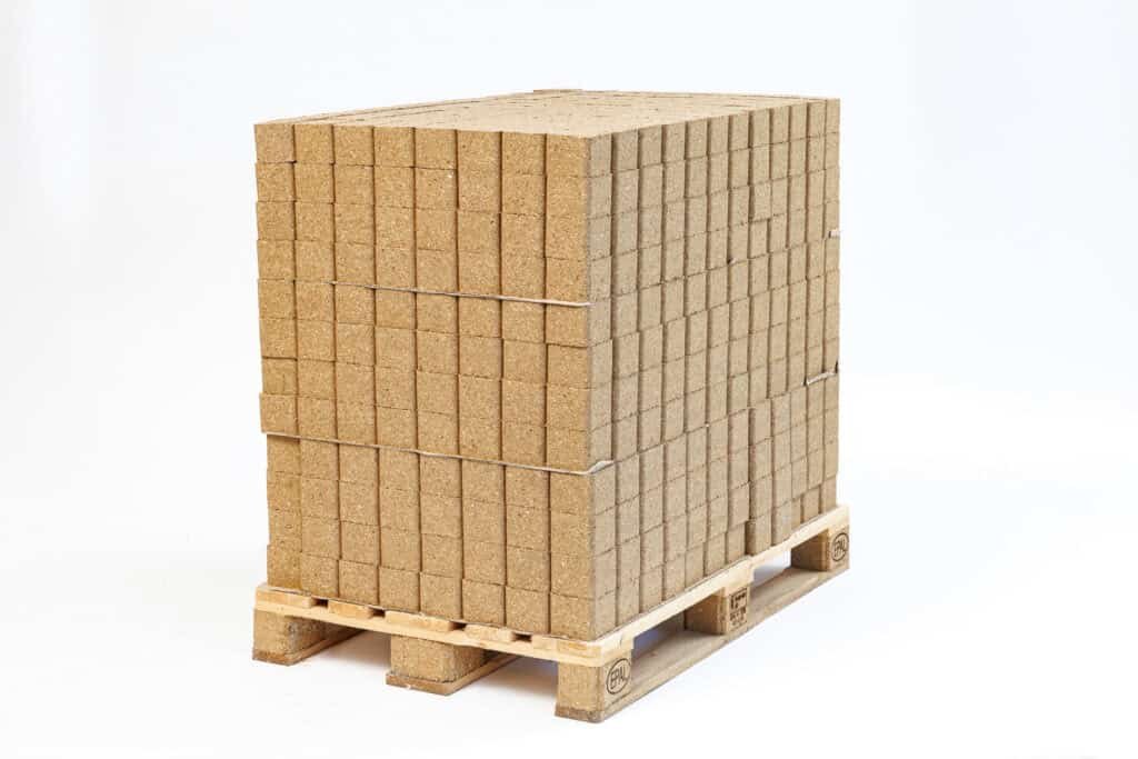 A stack of compressed blocks on a pallet with a white background.